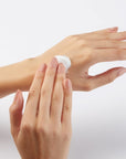 A model applying and smoothing in shea butter hand cream 